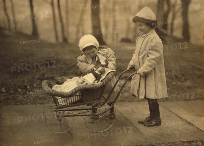 Two Young Girls Playing with Doll in Carriage, New York City, New York, USA, Lewis Hine for National Child Labor Committee, March 1912