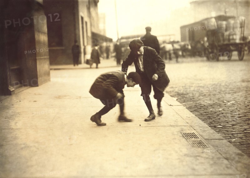 Two Young Boys Pitching Pennies on Sidewalk, Providence, Rhode Island, USA, Lewis Hine for National Child Labor Committee, November 1912