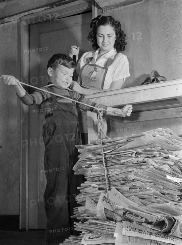 Mother Watching Young Son Tie up Large Bundle of Newspapers, as Conservation of Waste Paper will Save Millions of Dollars Annually for Uncle Sam during War Effort, Ann Rosener, Office of War Information, February 1942