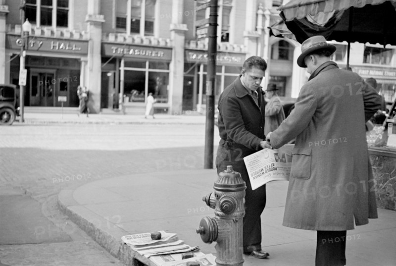 Man Selling Newspapers on Street Corner, Manchester, New Hampshire, USA, Carl Mydans for U.S. Resettlement Administration, August 1936