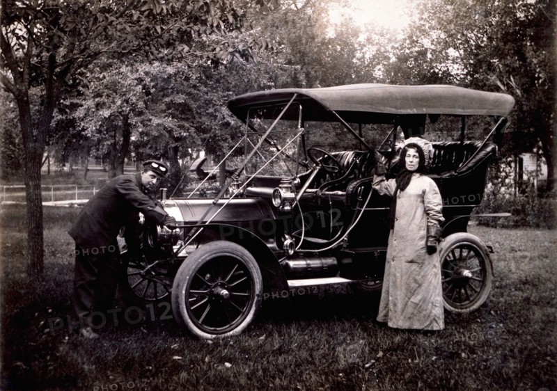 Woman Standing Beside Maxwell Touring Car and Driver Cranking Engine, USA, 1908