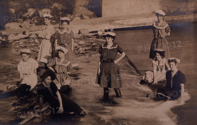 Group of Women in One-Piece Bathing Suits Wading and Sitting in Stream, circa 1907