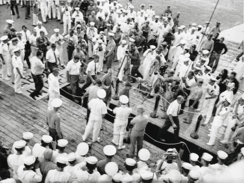 Astronauts Virgil "Gus" Grissom and John Young on Red Carpet on U.S.S. Intrepid on way to Debriefing after Completion of Gemini 3 Space Mission, 1965