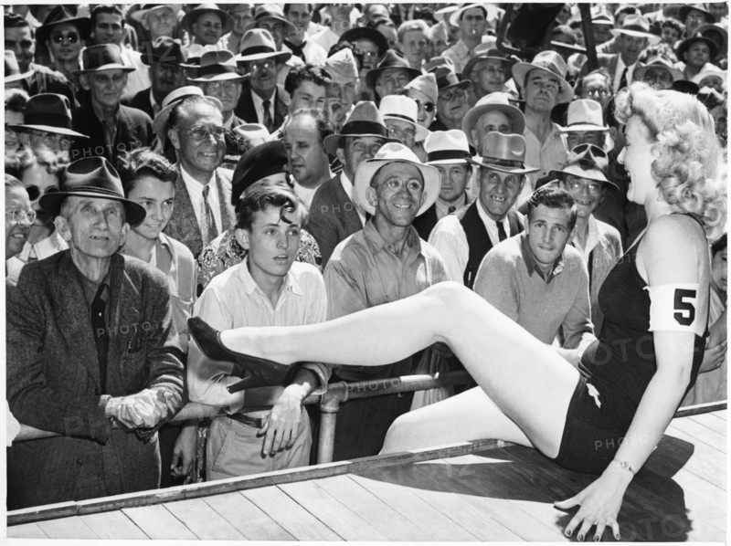 All-Male Crowd Watching Contestant in one-piece Bathing Suit Perform during Beauty Contest, Los Angeles, California, USA, 1943