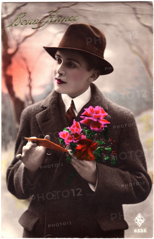 Woman Dressed in Man' Coat and Hat Holding Flowers and Card, "Bonne France", Hand-Colored French Postcard, circa 1927