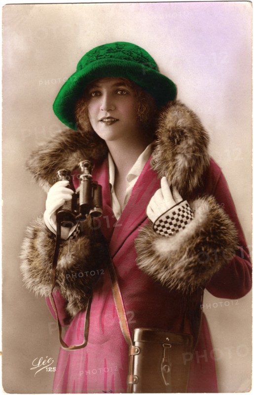 Fashionable Woman in Fur-Trimmed Coat and Green Hat Holding Binoculars, Hand-Colored Postcard, France, circa 1922