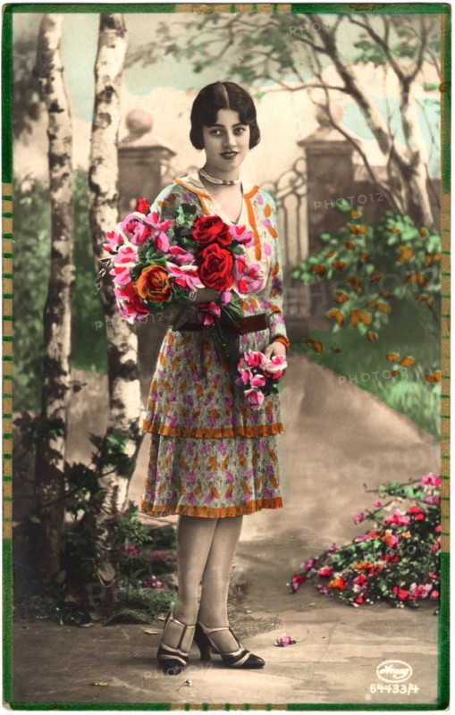 Fashionable Woman in Knee-Length Dress Standing Along Garden Path Holding Bouquet of Flowers, Portrait, hand-Colored Postcard, circa 1920's