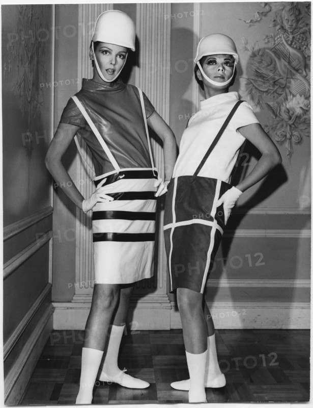 Two Fashion Models Wearing Sleek Interpretations of Andre Courreges’ Suspender Outfits Featuring Barrel Skirts with Button-Attached Suspenders and Leather Cowl-Neck Blouses, Presented by Samuel Robert, New York City, 1965