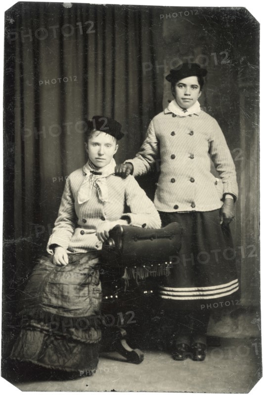 Portrait of Two Adult Women, One Seated, One Standing, with Matching Hats and Jackets, circa 1870