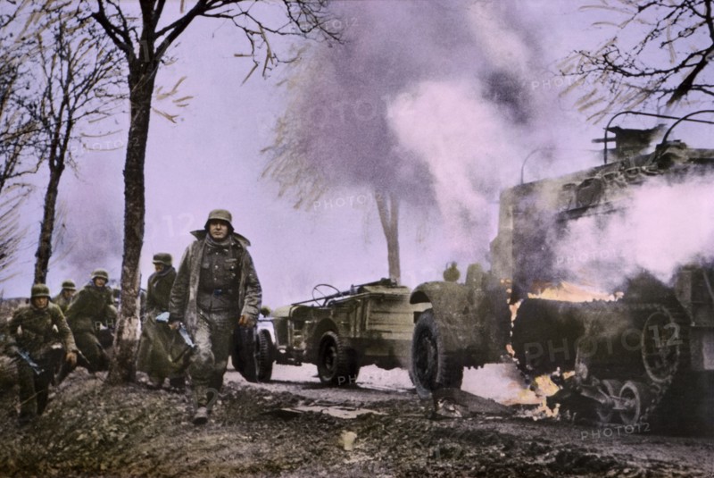 Enemy Troops Passing Burning U.S. Equipment, Ardennes-Alsace Campaign, Battle of the Bulge,1945