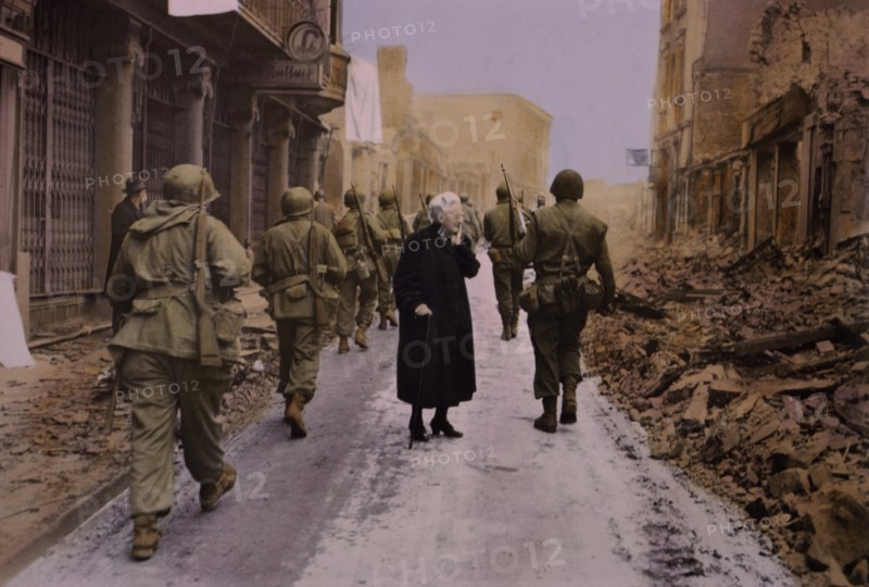 Infantry Troops Marching Through Town, Elderly Woman Looking at Demolished Buildings, Central Europe Campaign, Western Allied Invasion of Germany, 1945