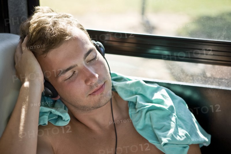 Young Man With Headphones Sleeping on Bus