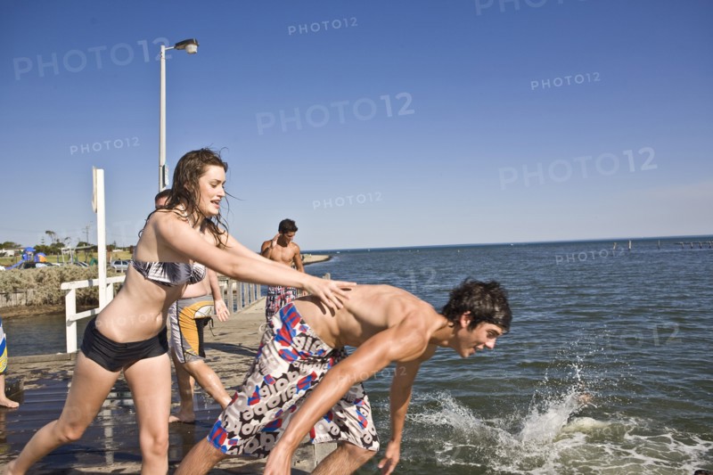 Woman Pushing Man into Water From Pier
