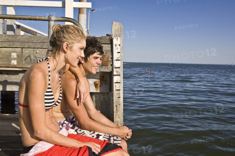 Young Couple Sitting on Edge of Pier