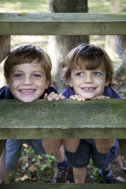 Smiling Boys Resting Chins on Wooden Step