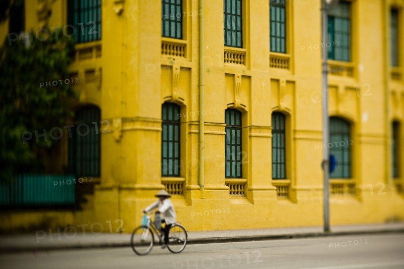 Bicyclist Passing Yellow Building, Ba Dinh Square, Hanoi, Vietnam