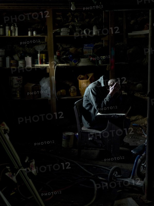 Man Sitting in Dark Basement