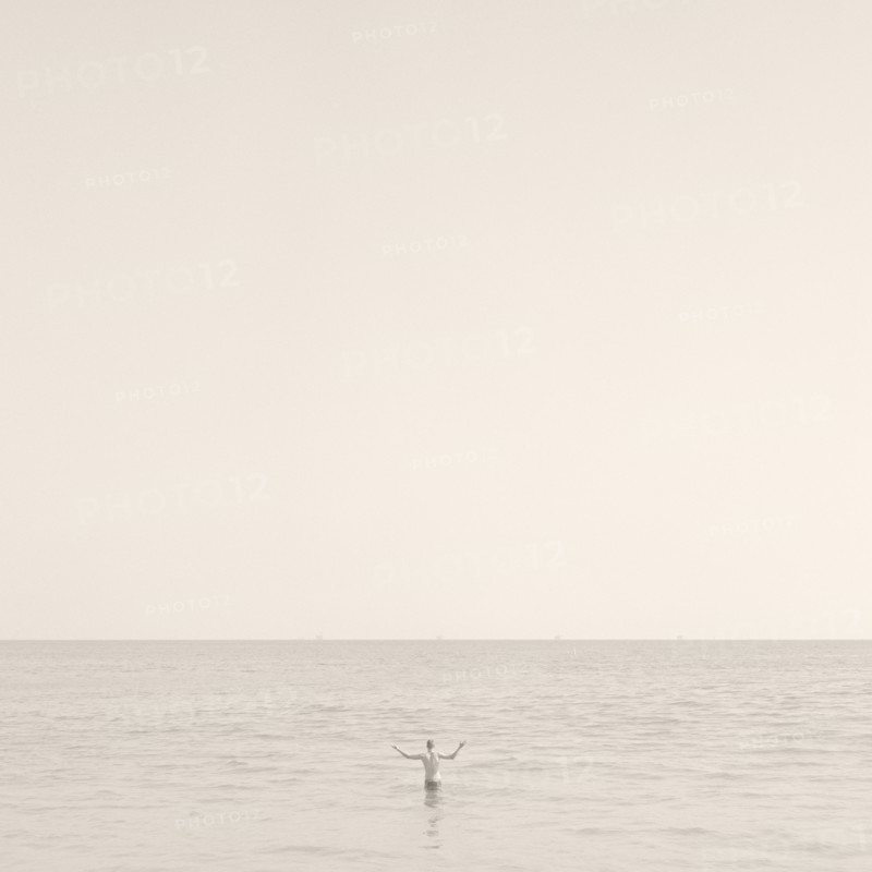 Man Standing in Ocean, Rear View