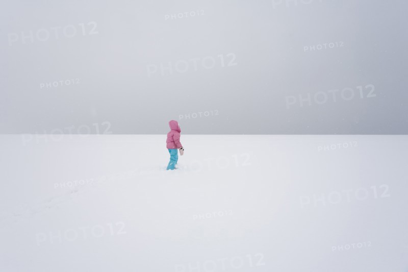 Lone Girl in Vast Snowy Field