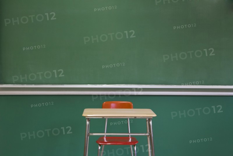 Empty Desk by Classroom Chalkboard
