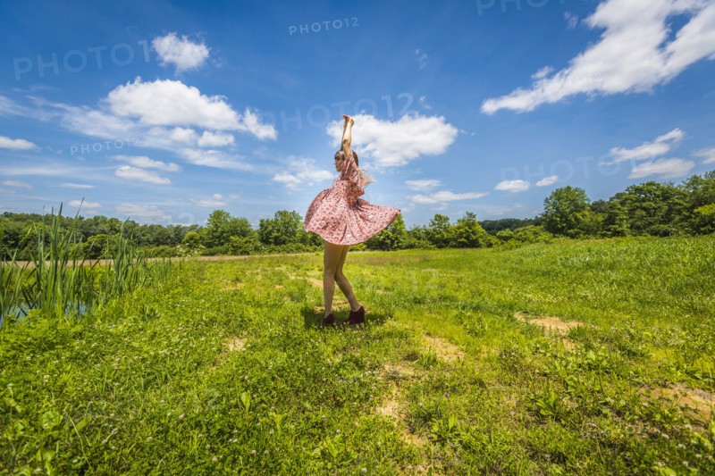 Young Adult Woman in Pink Dress Dancing in Field
