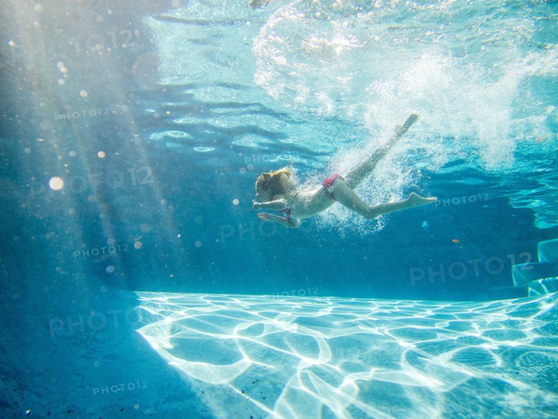 Girl Swimming Underwater in Pool, Profile