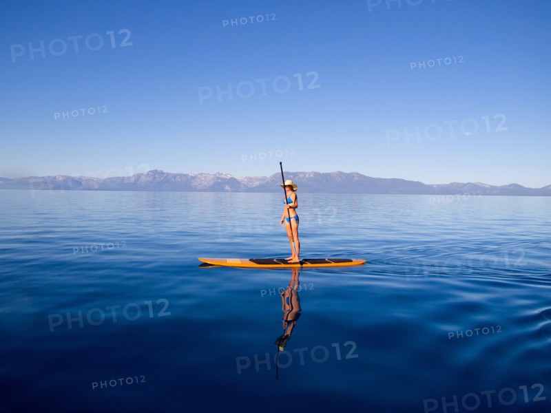 Woman Standing on Paddleboard Holding Paddle