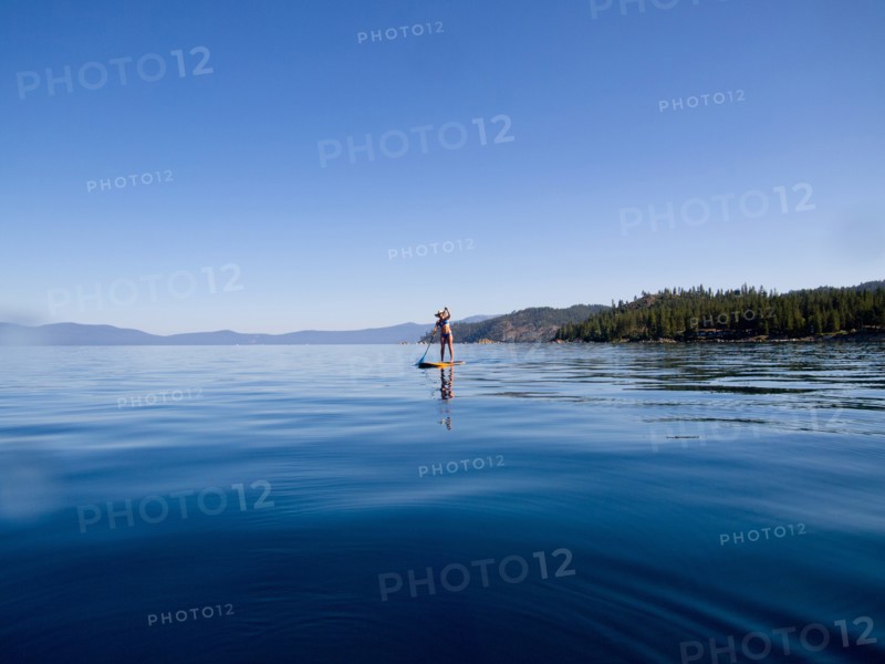 Woman Paddling on Lake in Distance