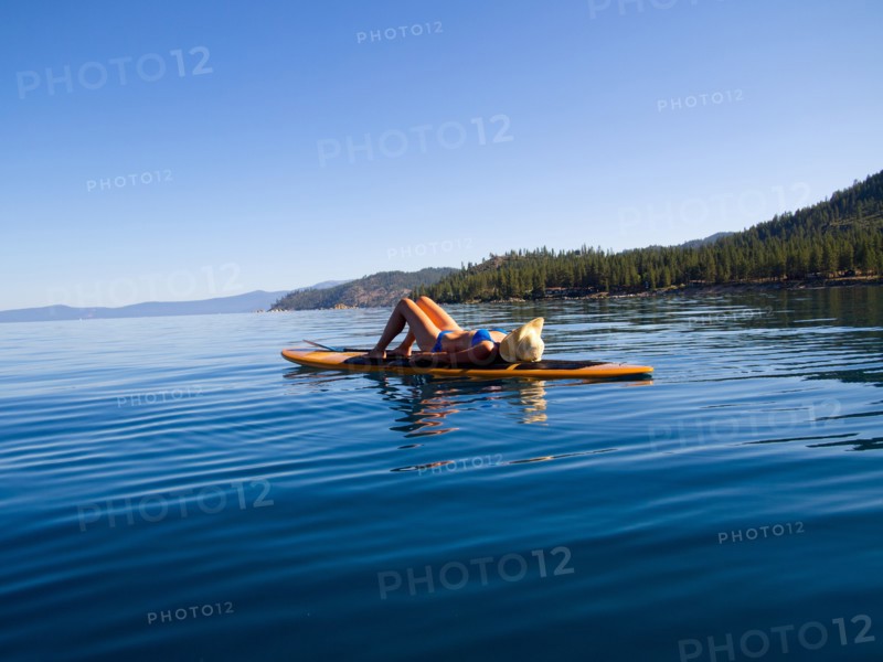 Woman Laying Down on Paddleboard on Lake 3