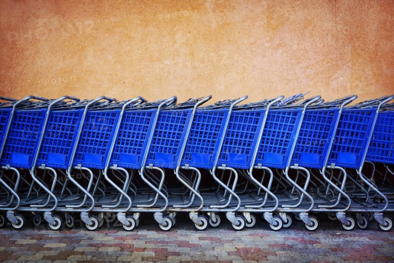 Line of Blue Shopping Carts Against Colorful Wall