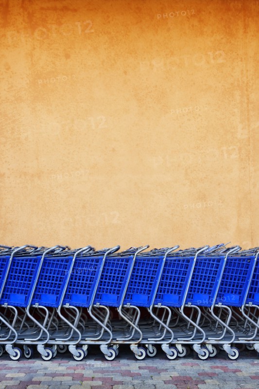 Line of Blue Shopping Carts Against Colorful Wall