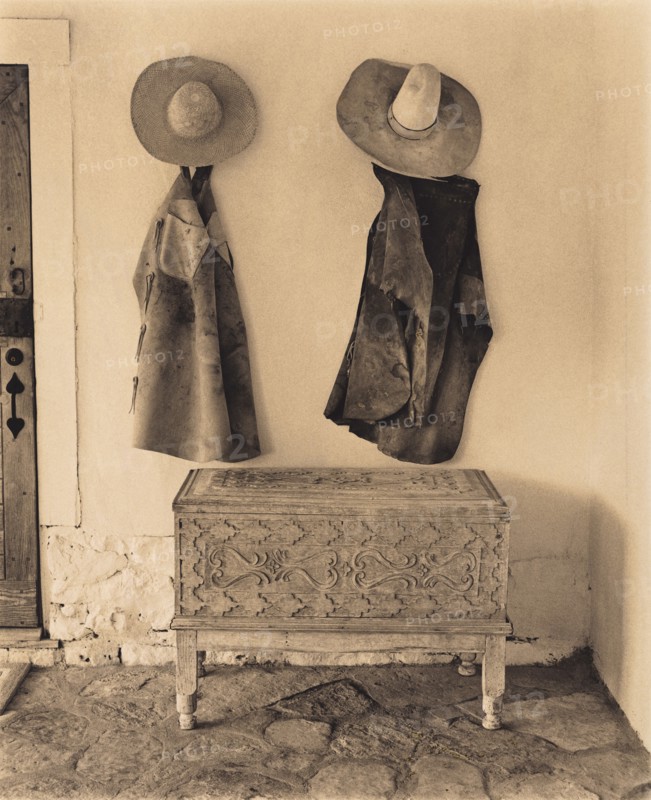 Cowboy Chaps and Hats Hanging on Wall