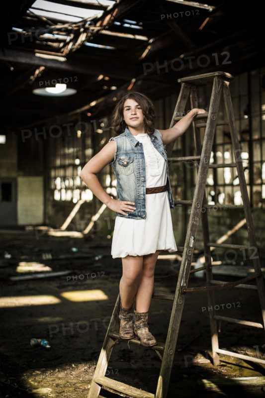 Girl Standing on Ladder in Abandoned Warehouse