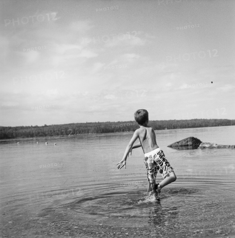 Young Boy Throwing Rock in Lake