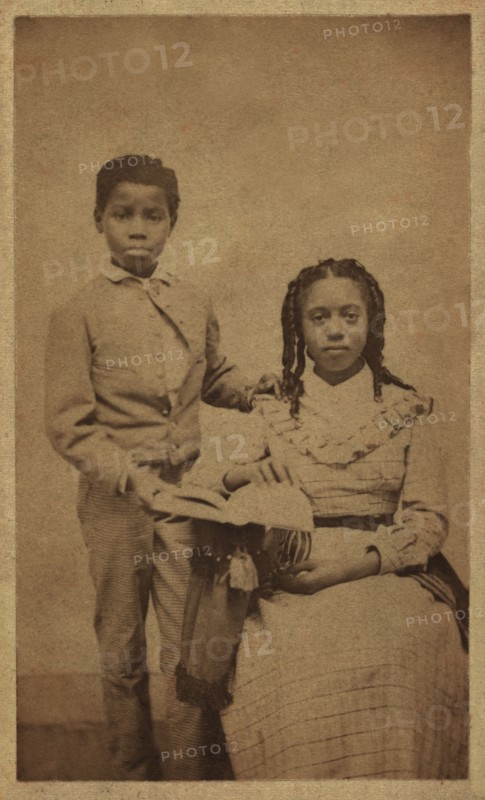 Full-length Portrait of an African American Boy Standing next to African American Girl, Seated with an Open Book, William A. Gladstone Collection of African American Photographs, late 1860's