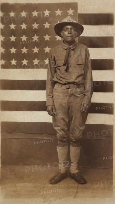 Full-length Portrait of an African American Soldier in Uniform with American Flag in Background, William A. Gladstone Collection of African American Photographs, 1914-18