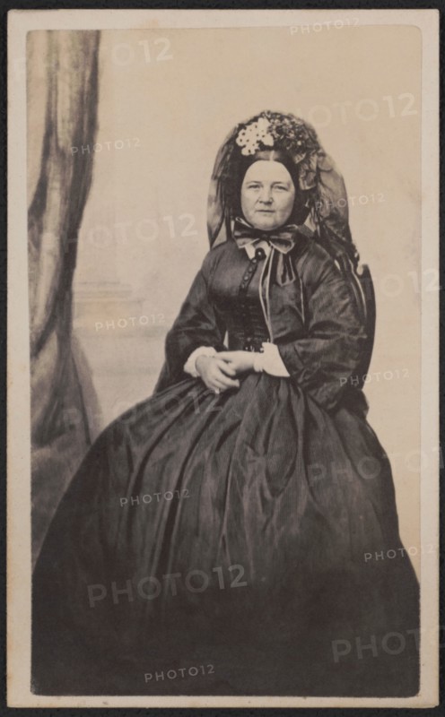 Full-Length Seated Portrait Mary Todd Lincoln in Mourning Attire after the death of her son, Willie in 1862, Photograph by Joseph Ward, possibly 1863, when she entered a period of half-mourning by evidence of a touch of white fabric at her wrists