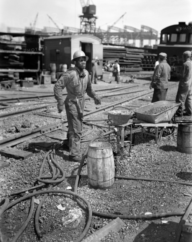 Rivet Heater engaged in Construction of Liberty Ship Frederick Douglass, Bethlehem-Fairfield Shipyards, Baltimore, Maryland, USA, Roger Smith, U.S. Office of War Information, May 1943