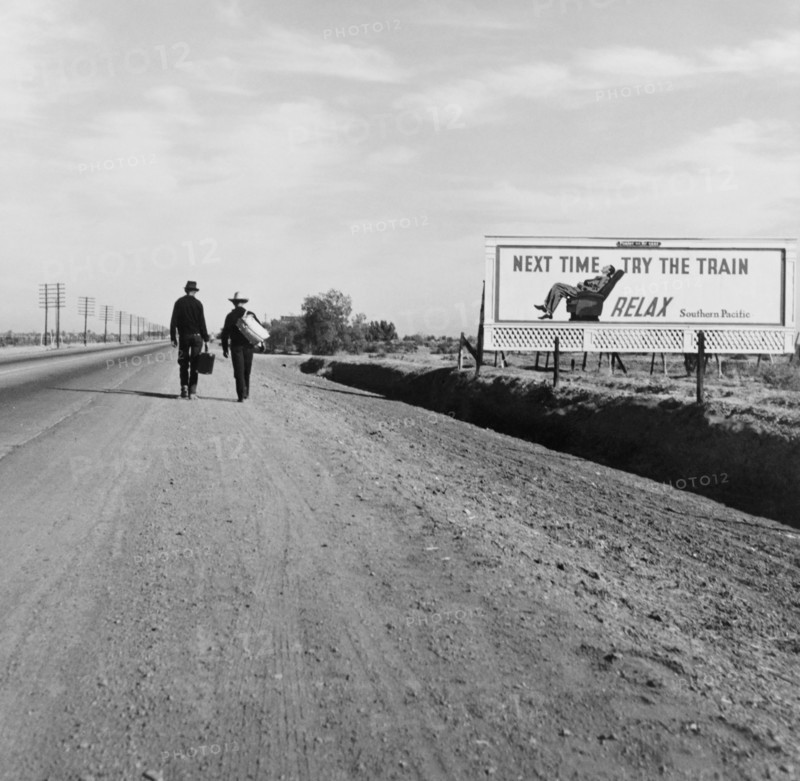 Rear View of Two Men Walking toward Los Angeles, California, USA, on Dirt Road near Billboard that says "Next Time Try the Train. Relax.", Dorothea Lange, U.S. Farm Security Administration, March 1937