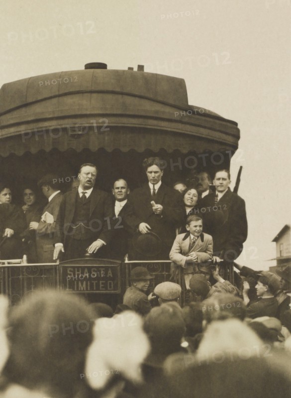 Theodore Roosevelt, with others, standing on back of Railroad car, speaking to crowd, Eugene, Oregon, USA, April 5, 1911