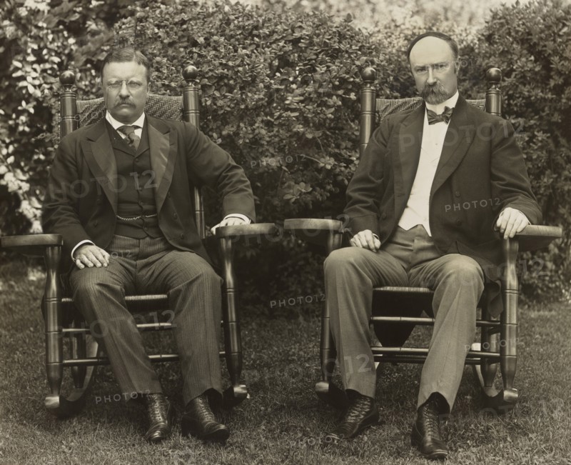U.S. President Theodore Roosevelt and Vice President Charles Fairbanks, seated in rocking chairs, facing front, on lawn at Sagamore Hill, Cove Neck, New York, USA, Pach Brothers, 1904