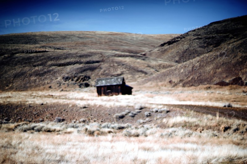 Old Wood Cabin amongst Rural Plains Landscape