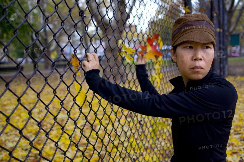 Half-Length Portrait of Woman Looking over her Shoulder While Standing at Fence