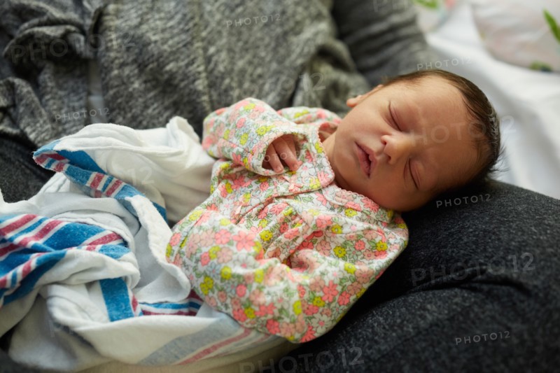 Newborn Baby Girl Sleeping in Mother's Lap in Hospital