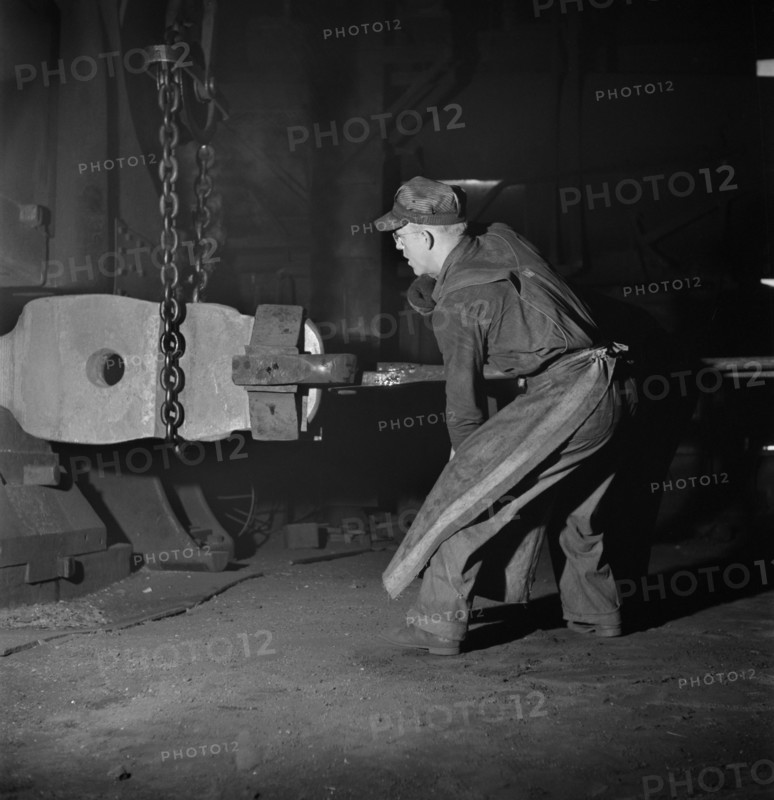Workman manipulating a Hot Forging which is being hammered under a Steam Hammer at Blacksmith Shop of Atchison