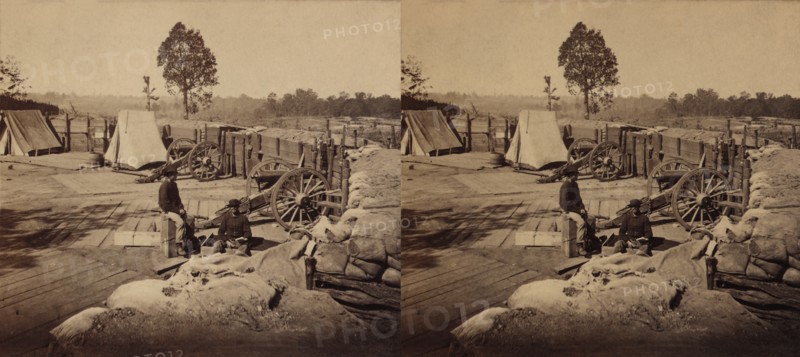Two Soldiers sitting amid Confederate Weapons and Fortifications