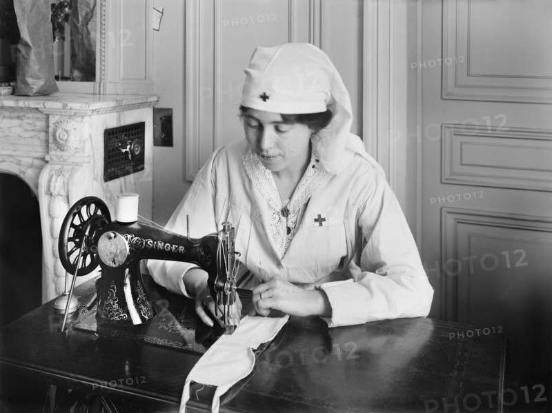 Female American Red Cross Worker stitching eye bandages on Sewing Machine in the American Red Cross Workrooms for Surgical Dressings
