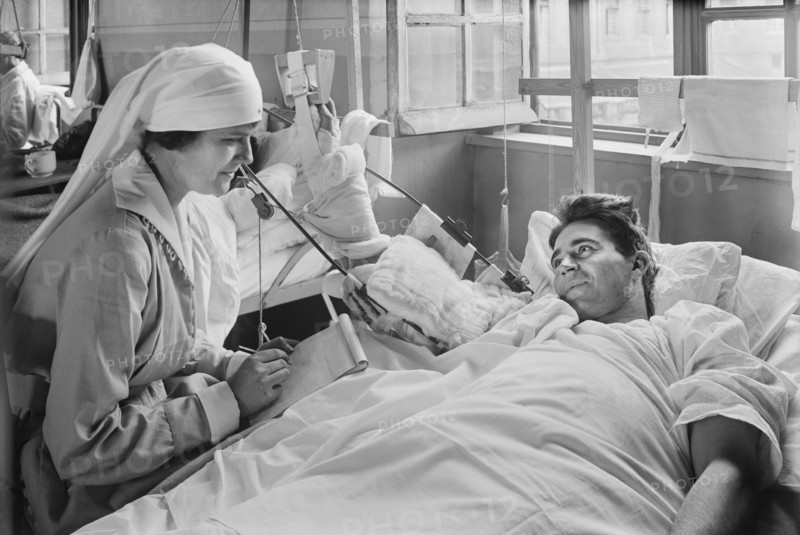 American Red Cross Worker writing letter for American Soldier whose Right Arm is Disabled