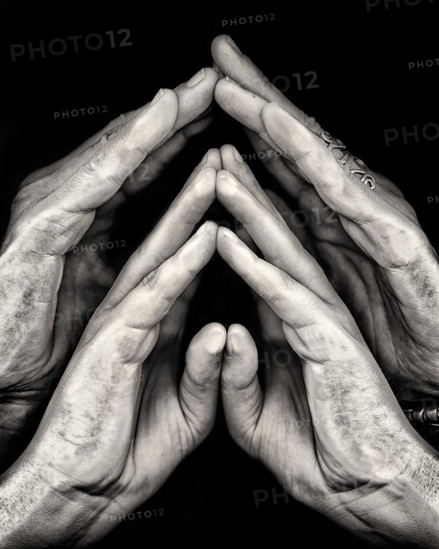 Close-Up of Two Pairs of Hands against Black Background