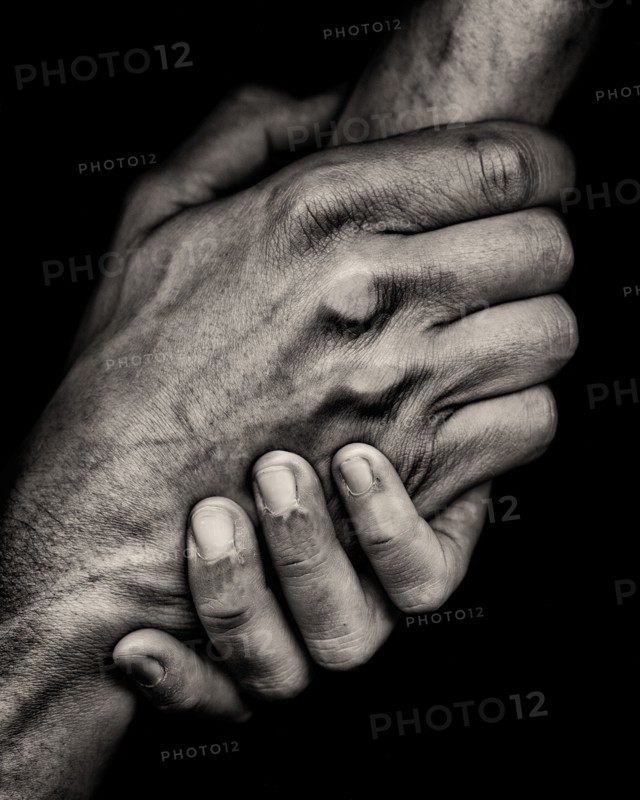 Two Clasped Hands against Black Background